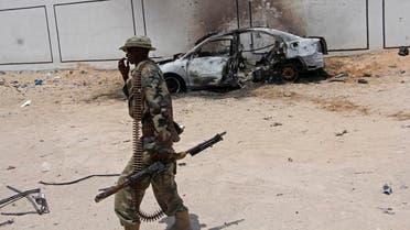 A Somali soldier walks near the wreckage of a car bomb blast near Aden Abdule international airport in Mogadishu, Somalia. (File photo: AP)