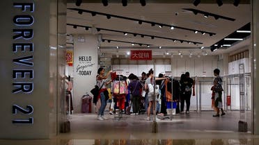 Women select clothing at an American fast fashion retailer "Forever 21" which is offering clearance discounts at a shopping mall after it pulled out from China's market, in Beijing, Tuesday, May 7, 2019. (AP)