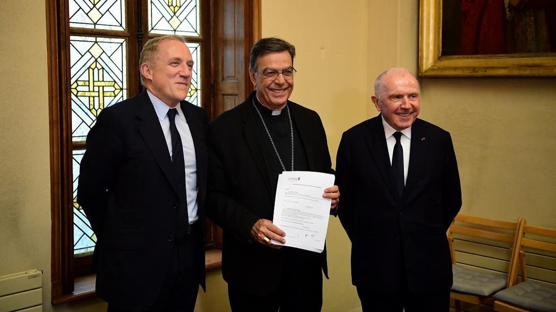 (From L) French luxury group Kering CEO François-Henri Pinault, Archbishop of Paris Michel Aupetit, and French billionaire businessman and majority shareholder and honorary chairman of Kering Francois Pinault pose after signing an agreement to raise money for the rebuild of Notre-Dame cathedral, on October 1, 2019 in Paris. (AFP) 