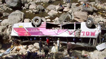 Men stand around a passenger bus that crashed in Huancavelica province, in Peru's southern Andes mountains, Sunday, Aug. 23, 2009. (AP)
