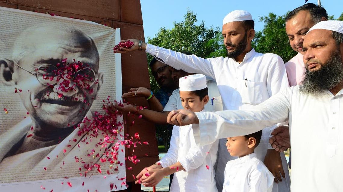 Indian Congress party workers showers rose petals on a portrait of Indian independence icon Mahatma Gandhi during a tribute to mark his 150th birth anniversary in Amritsar on October 2, 2019. (AFP)