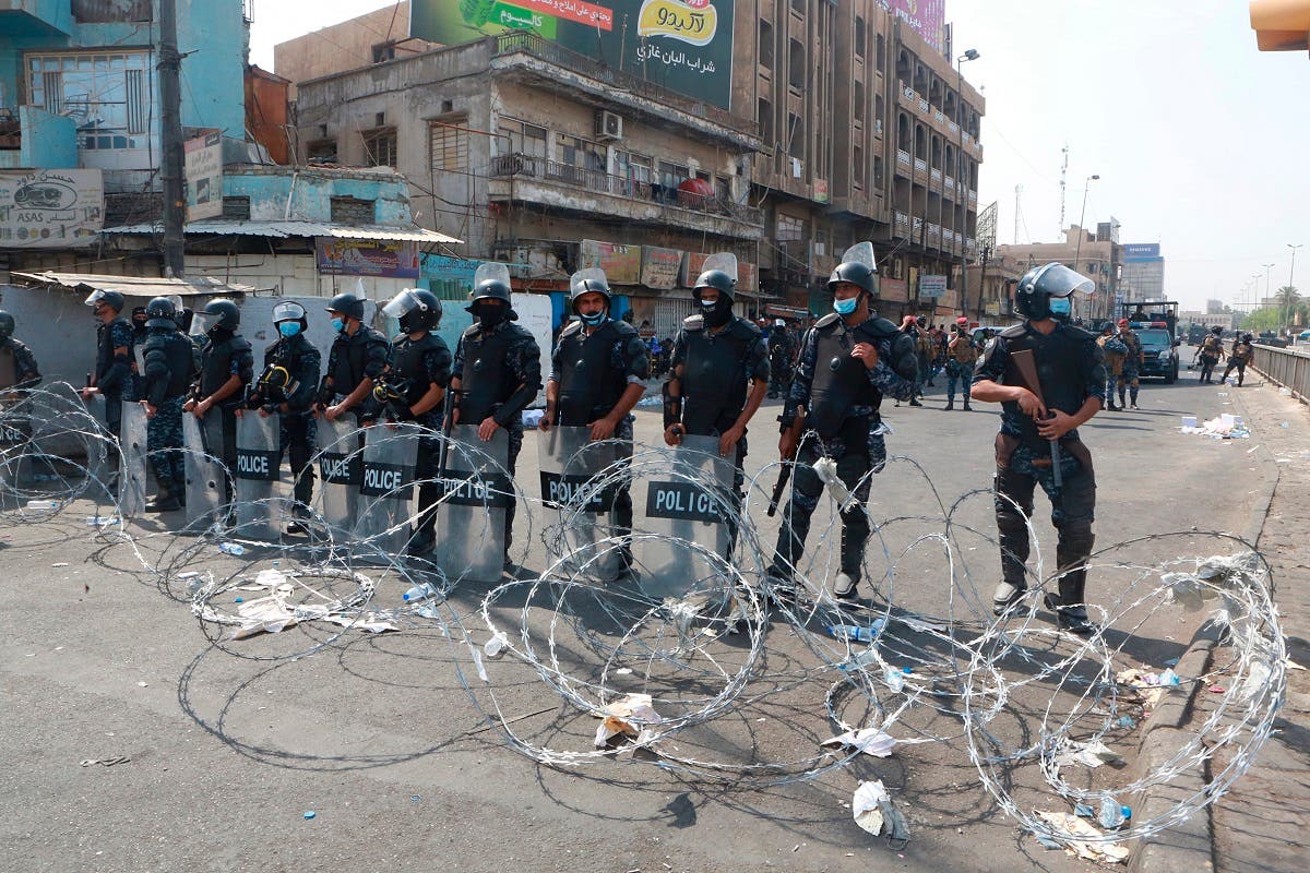 عراقی پولیس نے مظاہرین کو بغداد میں تحریر اسکوائر کی جانب جانے سے روکنے کے لیے شاہراہ پر خاردار تار لگا رکھا ہے۔