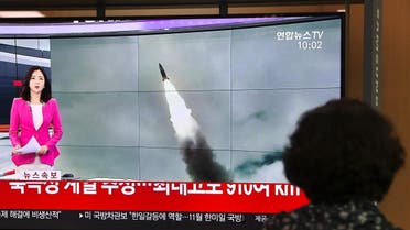 A woman watches a television news screen showing file footage of a North Korean missile launch, at a railway station in Seoul on October 2, 2019. (AFP)