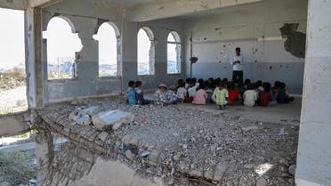 In a tour for the press organised by a damaged school in Yemen's third-city of Taez on September 3, 2019 to attract attention to their suffering, Yemeni children listen to their teacher on the first day of the new academic year in a destroyed classroom at their school's compound which was heavily damaged last year in an air strike during fighting between the Saudi-backed government forces and the Huthi rebels. The classes are given in the undamaged section of the school normally, but the tour was organised to show the press the extent of damage that the school sustained in an attempt to get funding for repairs.