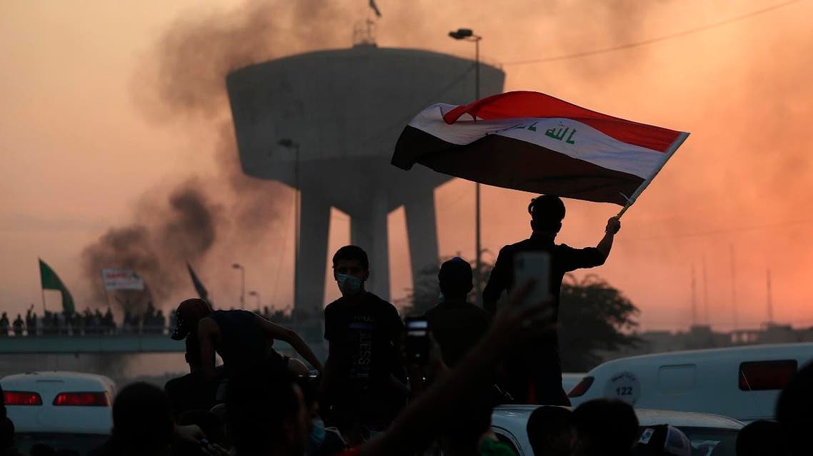 Anti-government protesters wave flags during a demonstration in Baghdad, Iraq. (AP)