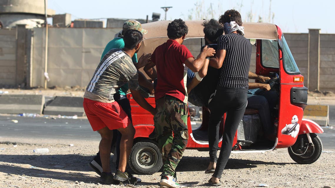 Iraqi men carry a wounded protester into a Tuk-Tuk during a demonstration against state corruption, failing public services, and unemployment, in the Iraqi capital Baghdad's central Khellani Square on October 4, 2019. (AFP)