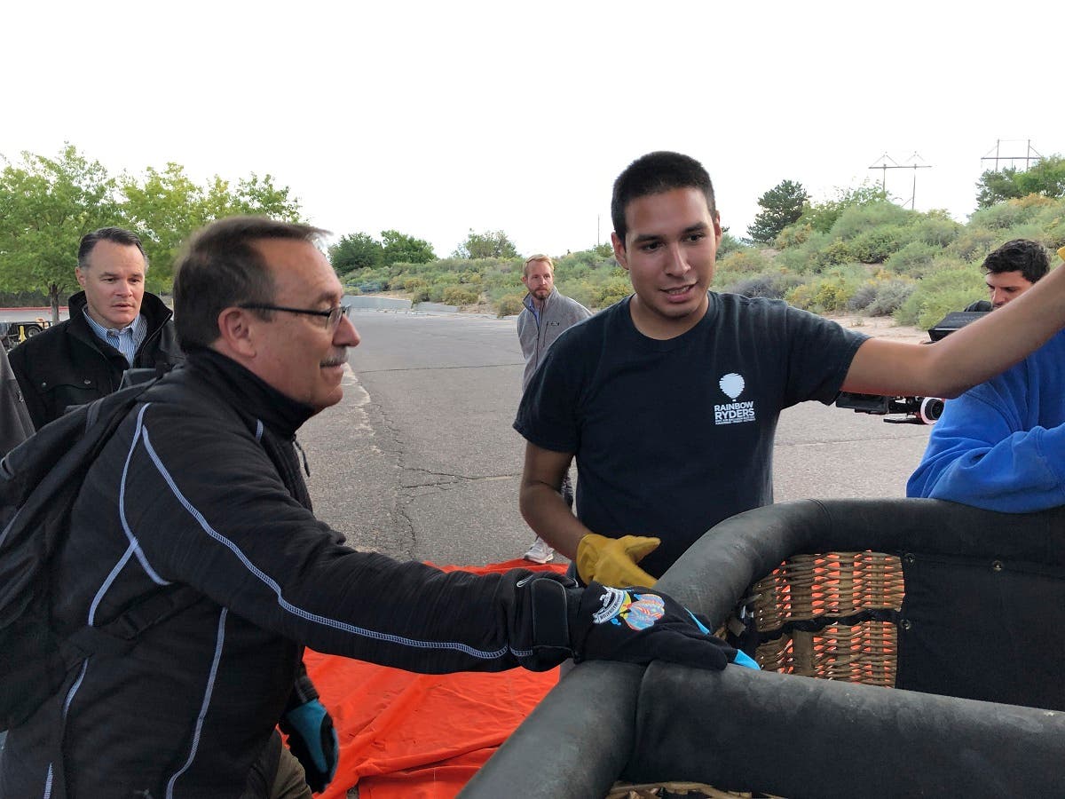 Elijah Sanchez (center), helps passenger board a hot air balloon in Albuquerque on October 1, 2019. (AP)