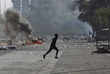 An Iraqi protester runs amidst clashes during a demonstration against state corruption, failing public services, and unemployment in the Iraqi capital Baghdad's central Khellani Square on October 4, 2019. (AFP)