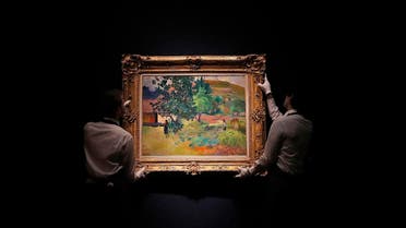 Christie’s employees hang up the painting ‘Te Fare (La maison)’ by Paul Gauguin at Christie’s in London. (File photo: AP)