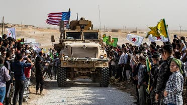 Syrian Kurds gather around a US armoured vehicle during a demonstration against Turkish threats next to a US-led international coalition base on the outskirts of Ras al-Ain town in Syria's Hasakeh province near the Turkish border on October 6, 2019. (AFP)