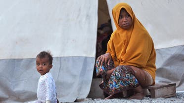 This picture taken on September 25, 2019 shows Ela (R) and her daughter Al (L) sitting in front of their tent at a temporary shelter, in Palu, Central Sulawesi, a year after the magnitude 7.5 quake and subsequent deluge razed swathes of the coastal city killing more than 4,300 people and displacing some 170,000 residents. (AFP)