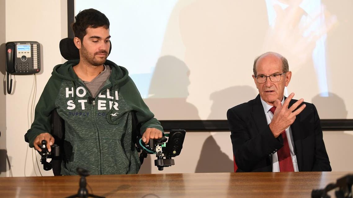 French doctor Alim Louis Benabid (R) and patient Thibault attend a press conference to present the brain-controlled exoskeleton in Grenoble on October 7, 2019. (AFP)