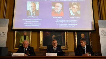 Members of the Nobel Committee for Physics (Bottom L-R) Chair of the Nobel Committee Mats Larsson, Secretary General of the Academy Goran K Hansson, and Ulf Danielsson sit in front of a screen displaying the portraits of the winners of the 2019 Nobel Prize in Physics (Up L-R) Canadian-American James Peebles, Swiss scientists Michel Mayor and Didier Queloz, at the Royal Swedish Academy of Sciences on October 8, 2019 in Stockholm. (AFP)