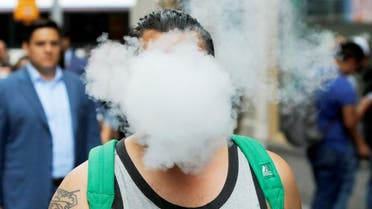 A man uses a vape as he walks on Broadway in New York City. (Reuters)