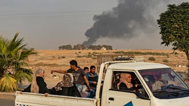 Civilians ride a pickup truck as smoke billows following Turkish bombardment on Syria’s northeastern town of Ras al-Ain in the Hasakeh province along the Turkish border on October 9, 2019. (AFP)