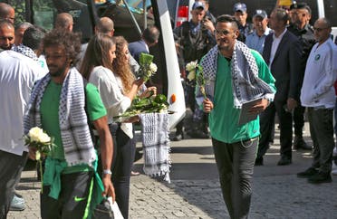 Palestinian women welcome Saudi Arabia’s national football players with flowers in Ramallah on October 13, 2019 upon the team’s arrival in the occupied Palestinian territories where they will play for the first time next week their match in the Asian qualifiers for the 2022 World Cup against Palestine. (AFP)
