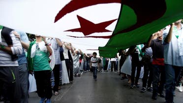 Demonstrators carry a national flag during a protest against the country's ruling elite and rejecting a December presidential election in Algiers, Algeria October 11, 2019. (Reuters)