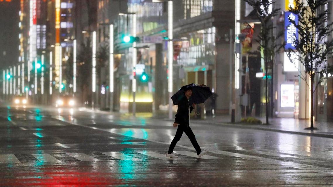 A man walks a pedestrian crossing at Ginza shopping district in the pouring rain due to Typhoon Hagibis in Tokyo. (AP)