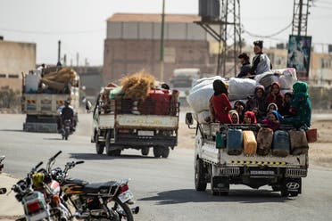 Displaced Syrians sit in the back of a pick up truck as Arab and Kurdish civilians flee amid Turkey’s military assault on Kurdish-controlled areas in northeastern Syria, on October 11, 2019. (AFP)
