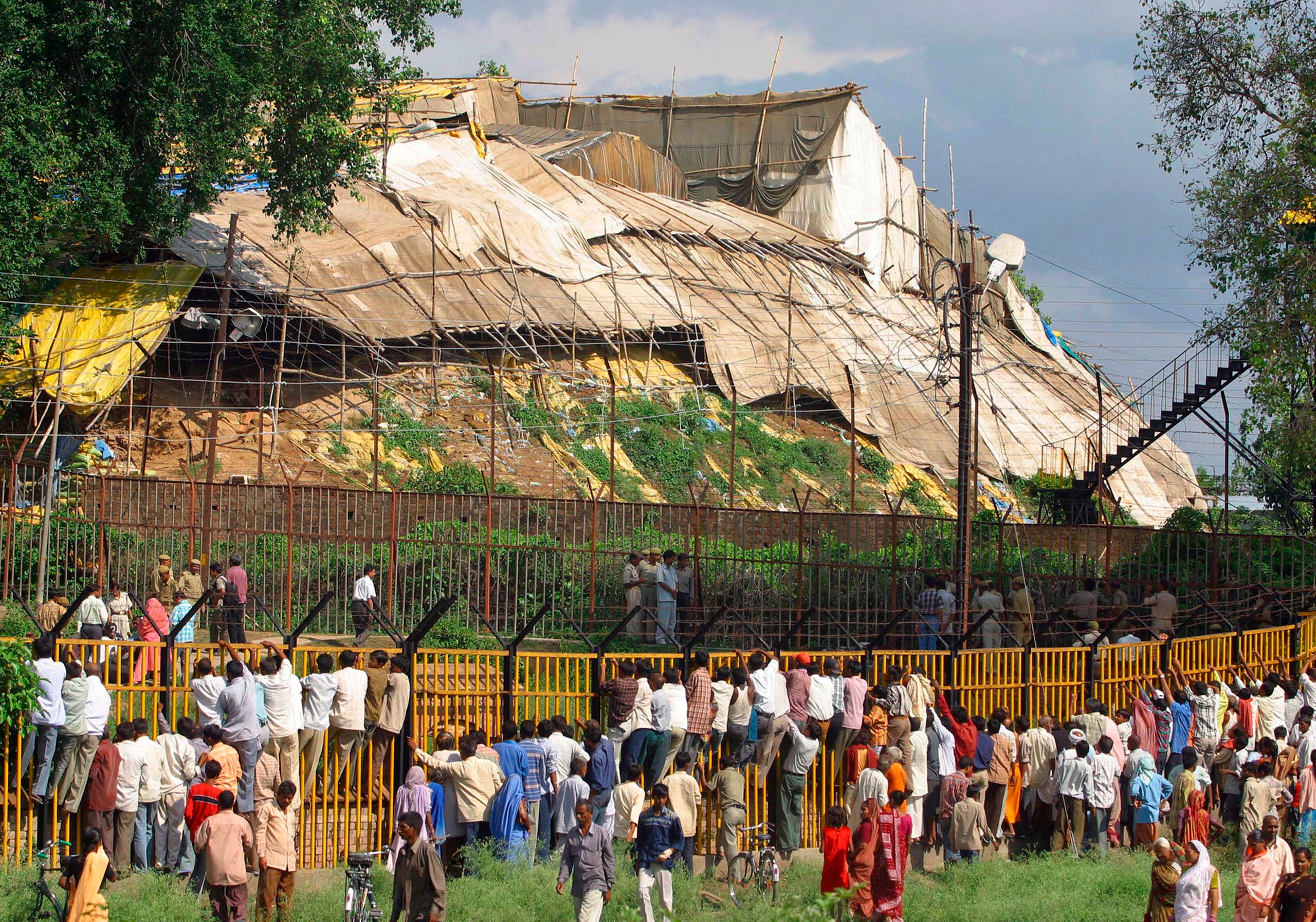 People look through the fence of the high-security complex of one of India’s most revered Hindu religious sites in Ayodhya, in the northern Indian state of Uttar Pradesh. (AP)
