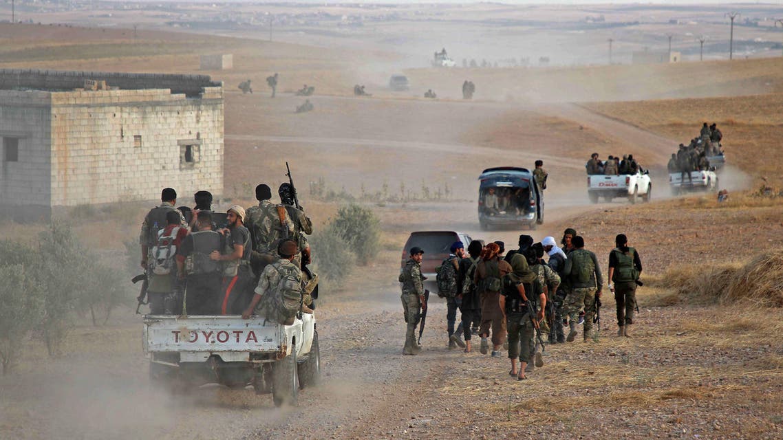 Turkey-backed Syrian fighters are transported in the back of pickup trucks on a road near the village of Qirata on the outskirts of the northern city of Manbij near the Turkish border, on October 14, 2019. (AFP)