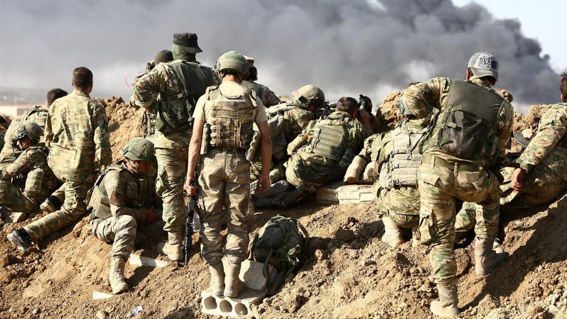 Turkish troops and Turkish-backed Syrian rebels gather outside the border town of Ras al-Ain. (AFP)