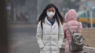 Girl wearing mouth mask with filter against air pollution, Beijing stock photo
