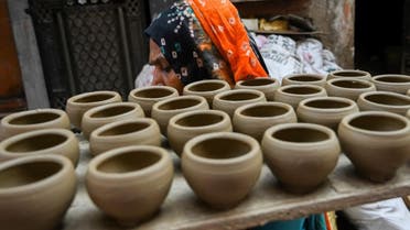 A woman carries earthen pots, at Potter's Village in New Delhi. (AFP)