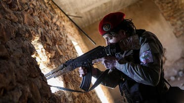 A Syrian fighter of the Turkish-backed Hamza Division aims a Kalashnikov assault rifle from a position in the village of Ulashli near the frontline in the northeast of Aleppo province. (File photo: AFP)