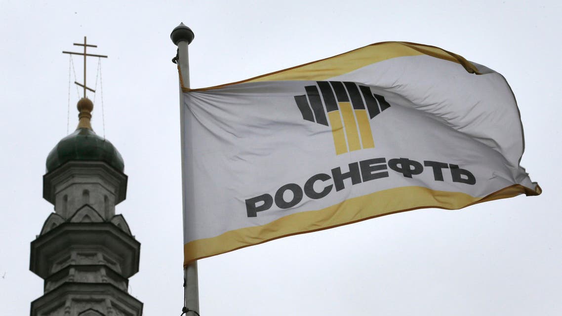 In this Thursday, Oct. 18, 2012 file photo, Rosneft's banner flies next to a church in Moscow, Russia. Russia's largest oil company Rosneft said Thursday, Nov. 1, 2012, that it doubled its profit in the third quarter of the year thanks to strong sales and higher oil prices. Rosneft's net profit rose to $5.7 billion in the July-September period from $2.8 billion last year. The increase was greater than expected in the markets and came despite a modest increase in revenues from $24.6 billion to $25.5 billion. (AP Photo/Mikhail Metzel, File)