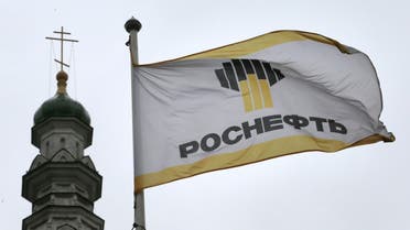 In this Thursday, Oct. 18, 2012 file photo, Rosneft's banner flies next to a church in Moscow, Russia. Russia's largest oil company Rosneft said Thursday, Nov. 1, 2012, that it doubled its profit in the third quarter of the year thanks to strong sales and higher oil prices. Rosneft's net profit rose to $5.7 billion in the July-September period from $2.8 billion last year. The increase was greater than expected in the markets and came despite a modest increase in revenues from $24.6 billion to $25.5 billion. (AP Photo/Mikhail Metzel, File)