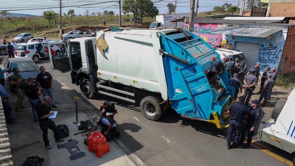 Policemen remain next to guns, money bags and a truck seized to criminals who raided the cargo terminal of the Viracopos International Airport, in Campinas, Sao Paulo state, Brazil, on October 17, 2019. (AFP)