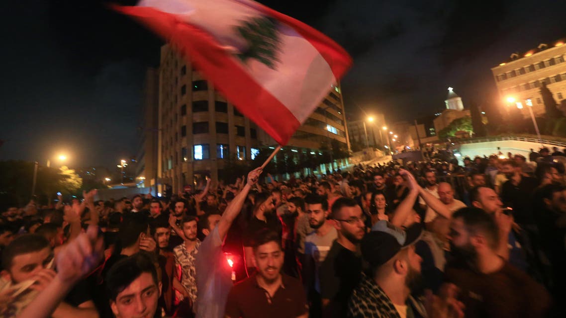 Demonstrators wave a flag during a protest against a government decision to tax calls made on messaging applications on October 17, 2019 outside the government palace in Beirut. (AFP)