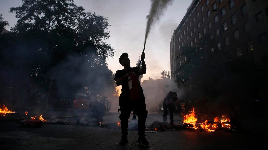Demonstrators set up barricades following a mass fare-dodging protest in downtown Santiago. afp