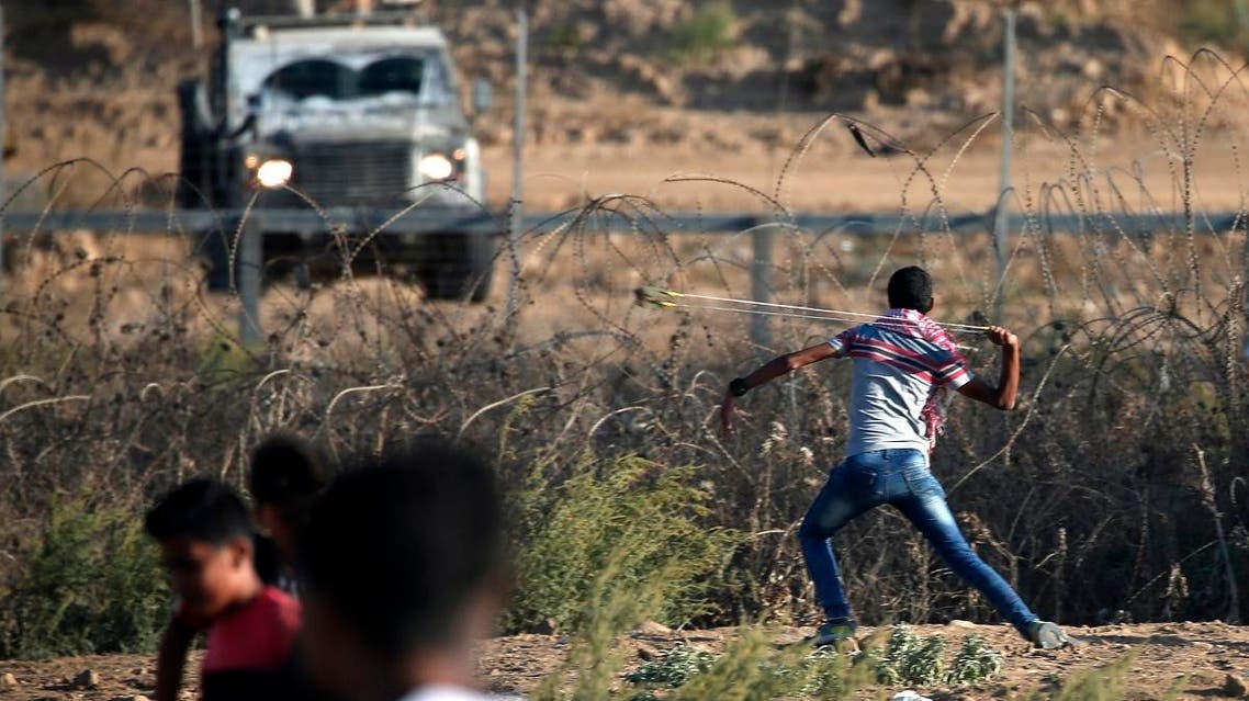 A Palestinian protester uses a slingshot to throw a stone at Israeli forces amidst clashes during a demonstration along the border with Israel east of Bureij in the central Gaza Strip on October 18, 2019. (AFP)