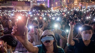 Attendees shout slogans and hold their mobile phones during a rally to show support for pro-democracy protesters in Hong Kong on October 19, 2019. (AP)
