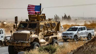 A US soldier sits atop an armoured vehicle during a demonstration by Syrian Kurds against Turkish threats next to a base for the US-led international coalition on the outskirts of Ras al-Ain town. (File photo: AFP)