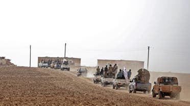 A convoy of pickup trucks transports Turkey-backed Syrian fighters on the road between the Syrian towns of Tal Abyad and Kobane on the Turkish border on October 16, 2019 (AFP)