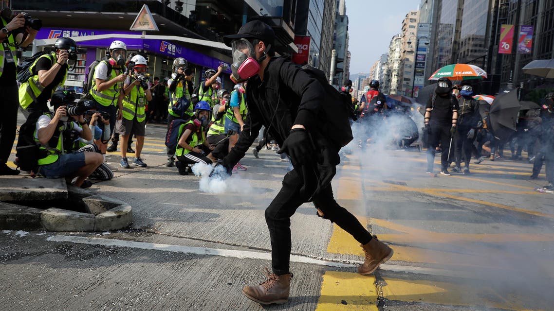 A protester carries away a tear gas canister during a rally in Hong Kong, Sunday, Oct. 20, 2019. (AP)