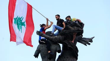Demonstrators stand on a statue in Martyrs' Square during an anti-government protest in downtown Beirut. (Reuters)