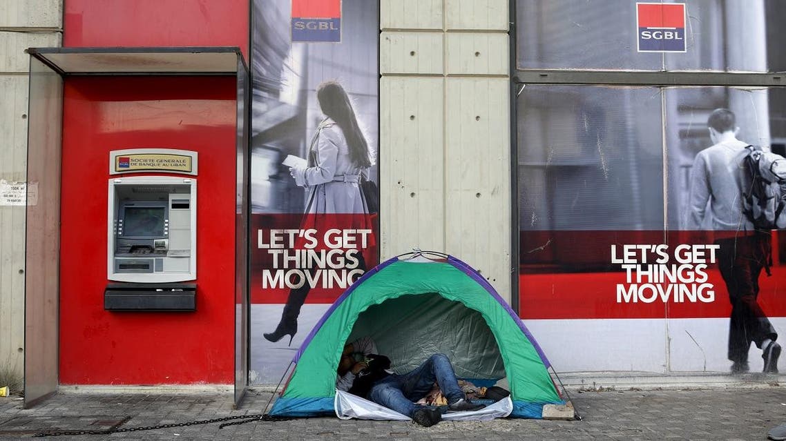 A Lebanese protester rests in a tent set up at the entrance of a bank in downtown Beirut. (AFP)