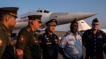Russian and South African officers speak in front of a Russian Air Force Tupolev Tu-160 "Blackjack", a supersonic variable-sweep wing heavy strategic bomber, is parked on the tarmac at the Waterkloof Air force Base in Centurion, south of Pretoria, northeastern South Africa, on October 23, 2019. (AFP)
