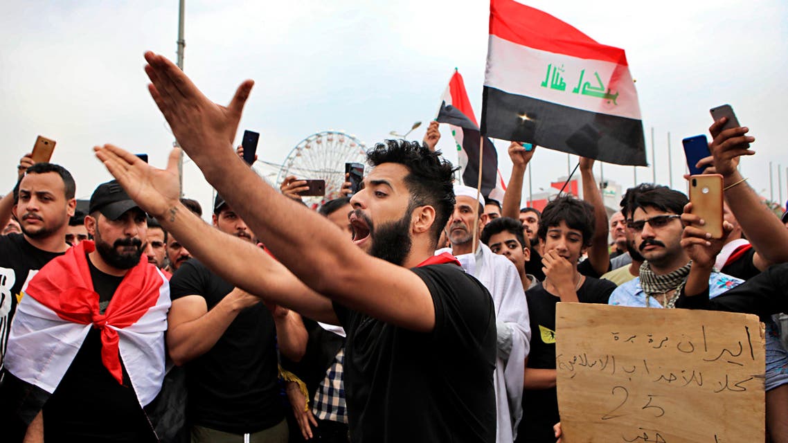 Anti-government protesters chant slogans and hold a placard with Arabic that reads "Iran out, all Islamic parties I want my right" during a demonstration in Basra, Iraq, (AP)