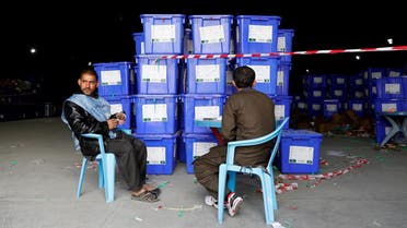 Afghan election commission workers sit next to ballot boxes and election material at a warehouse in Kabul. (Reuters)
