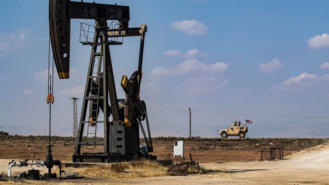 A US military vehicle, part of a convoy arriving from northern Iraq, drives past an oil pump jack in the countryside of Syria’s northeastern city of Qamishli on October 26, 2019. (AFP)