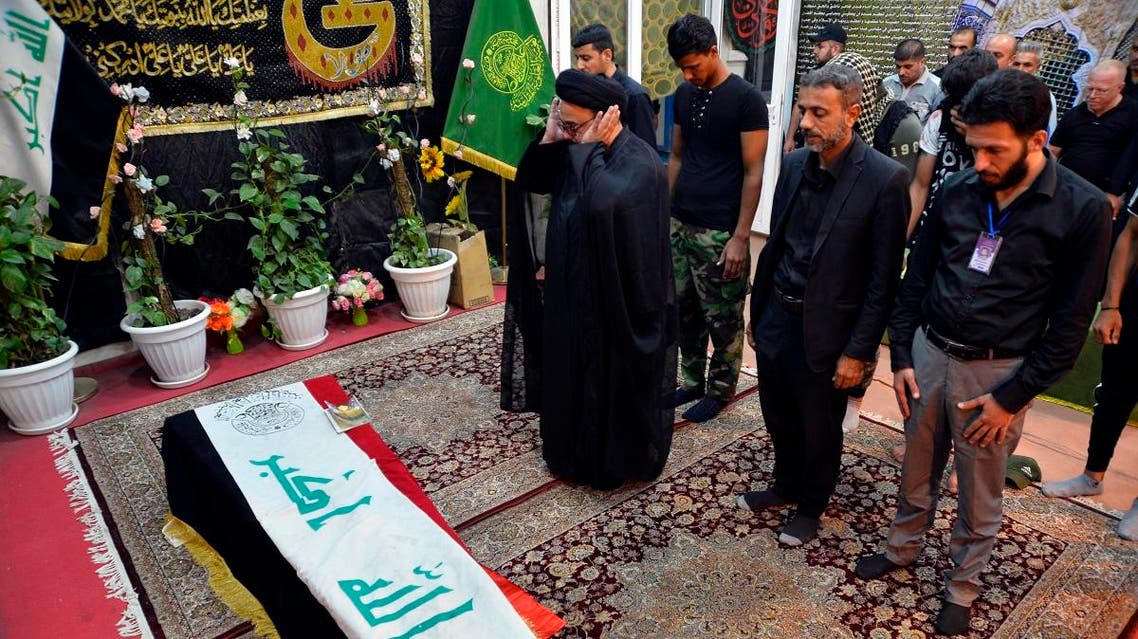 Mourners pray over the flag-draped coffin of a member of Iraq's Shiite Muslim Hashed al-Shaabi (Popular Mobilization units) paramilitary force during his funeral in the central holy shrine city of Najaf on October 26, 2019. (AFP)