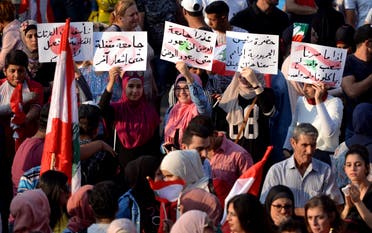 Protesters carry signs in Tripoli, Lebanon (Reuters)