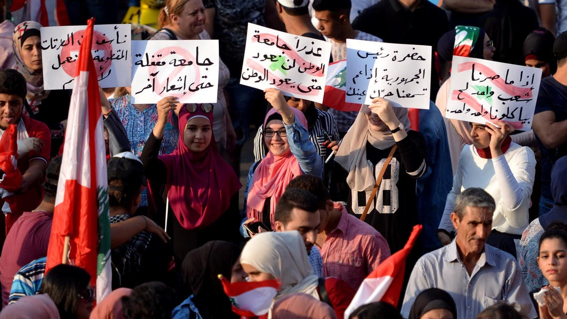 Protesters carry signs in Tripoli, Lebanon (Reuters)