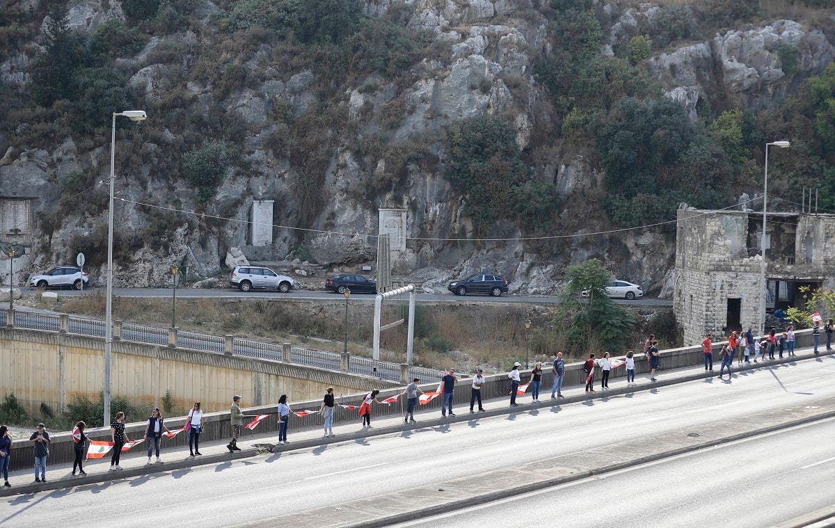 Lebanese protesters hold hands to form a human chain along the coast from north to south as a symbol of unity, during ongoing anti-government demonstrations in Nahr al-Kalb north of Lebanon's capital Beirut on October 27, 2019. (AFP)