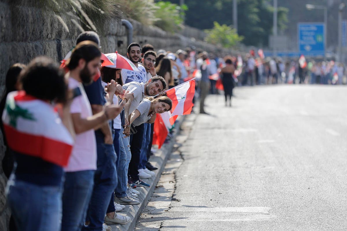 Lebanese protesters hold hands to form a human chain along the coast from north to south as a symbol of unity, during ongoing anti-government demonstrations in Nahr al-Kalb north of Lebanon's capital Beirut on October 27, 2019. (AFP)